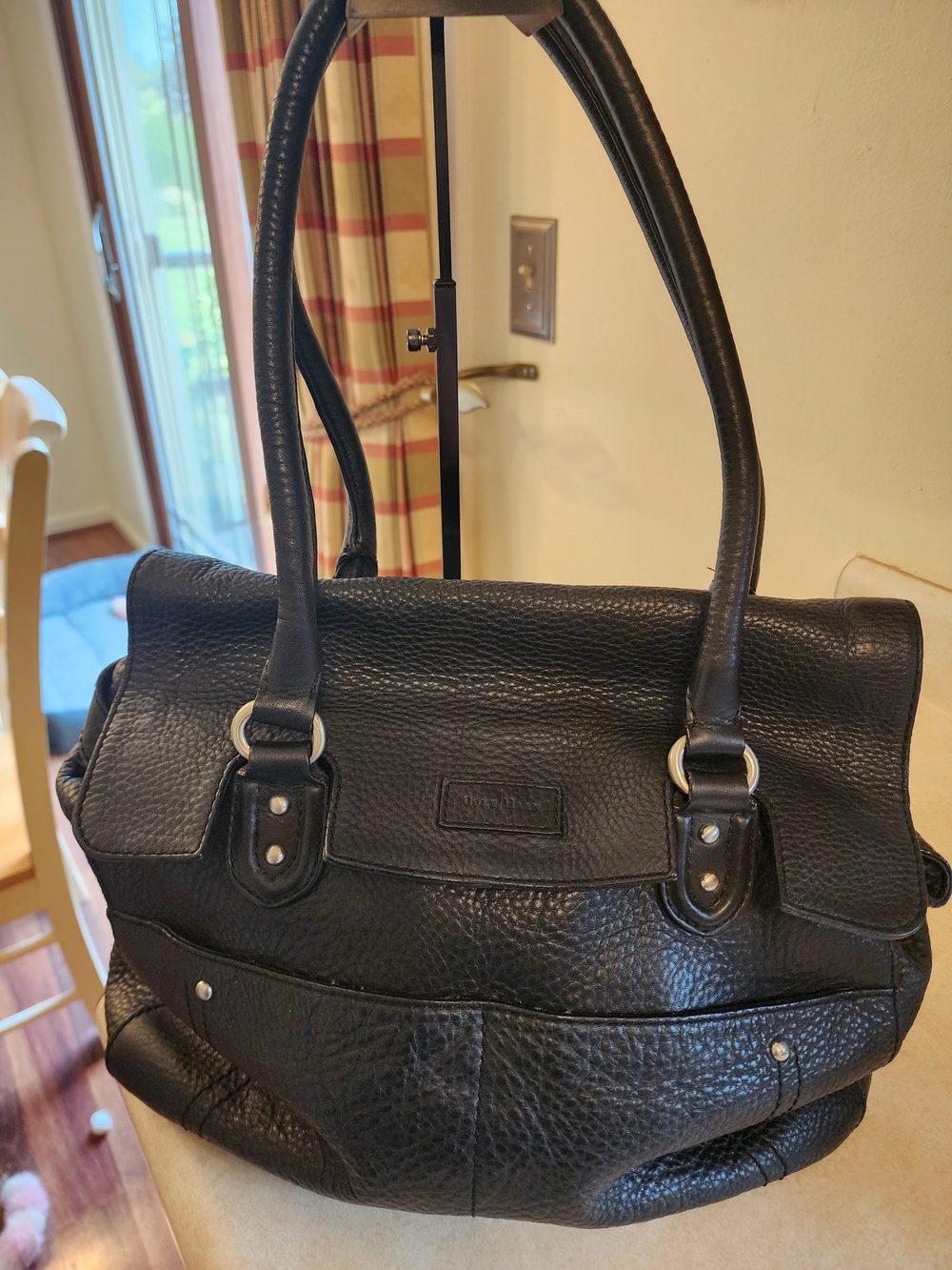 Cole Haan pebbled leather tote bag features silver hardware and a front flap